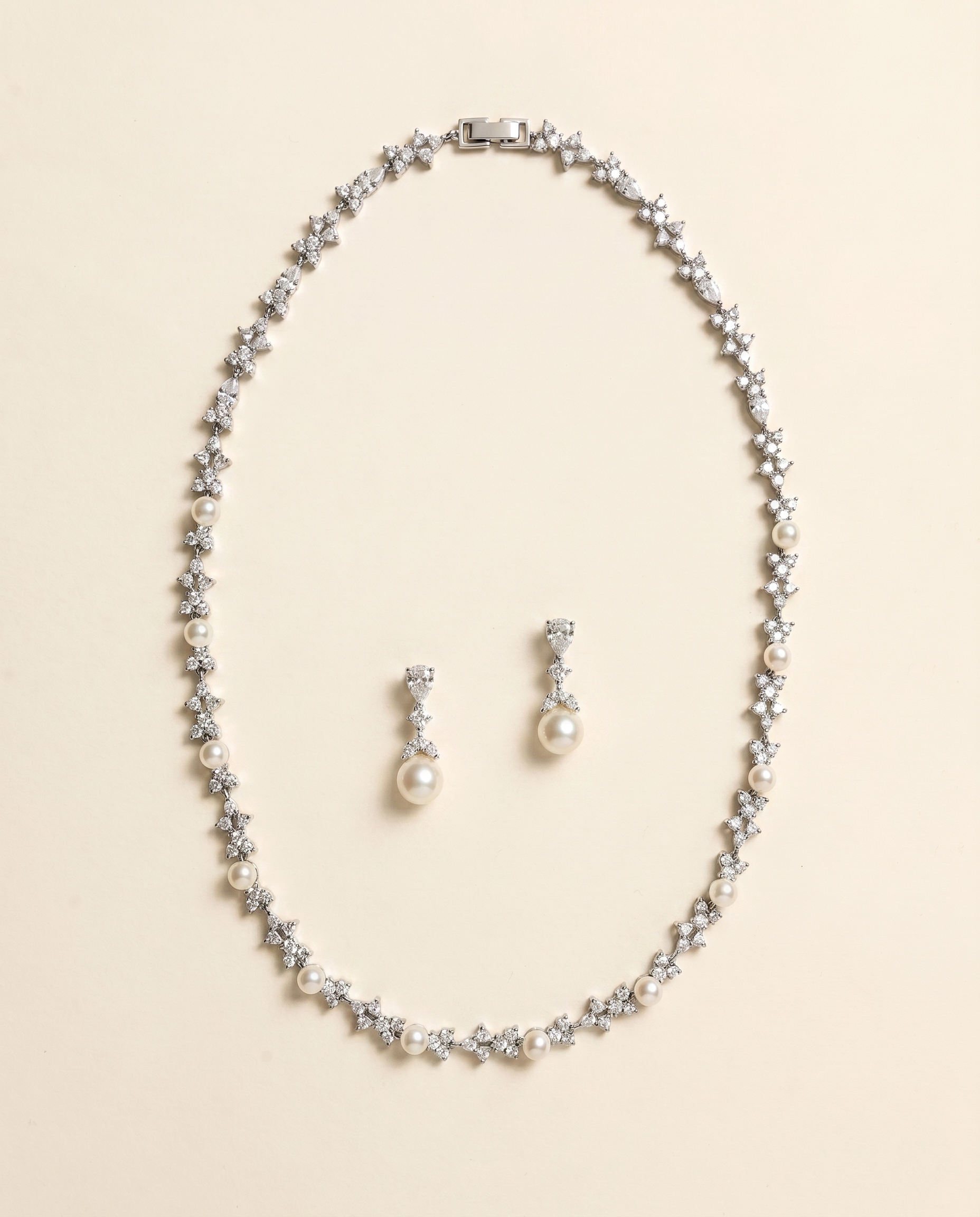 A necklace and earrings set made of silver and white pearls and diamonds.