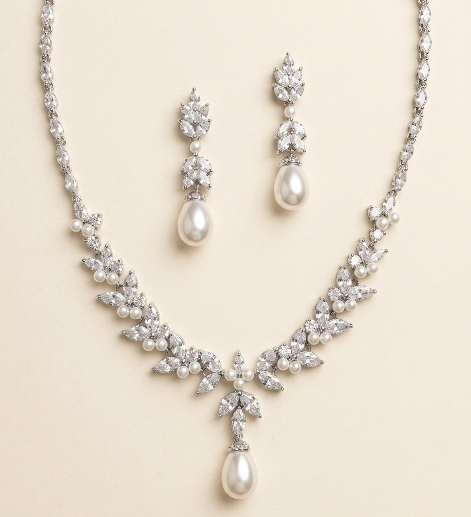 a beautiful necklace and earrings set made of white pearls and diamonds, creating an elegant and sophisticated look.