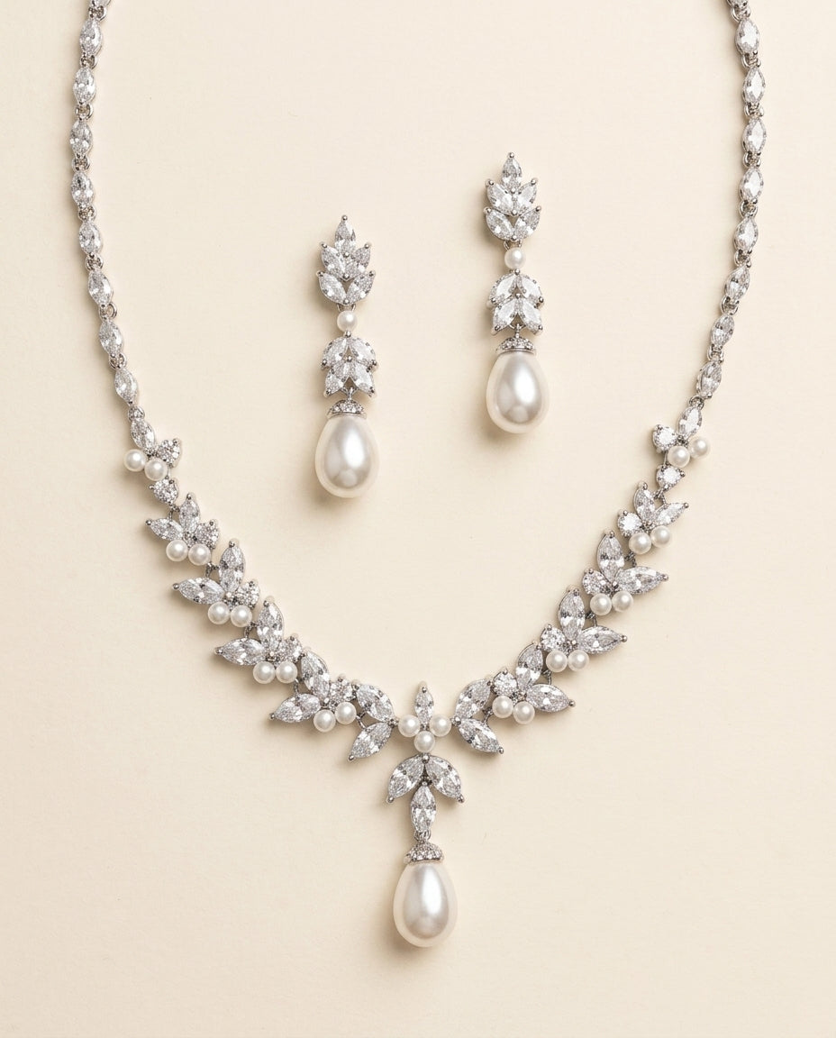 a beautiful necklace and earrings set made of white pearls and diamonds, creating an elegant and sophisticated look.