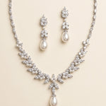 a beautiful necklace and earrings set made of white pearls and diamonds, creating an elegant and sophisticated look.