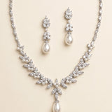 a beautiful necklace and earrings set made of white pearls and diamonds, creating an elegant and sophisticated look.