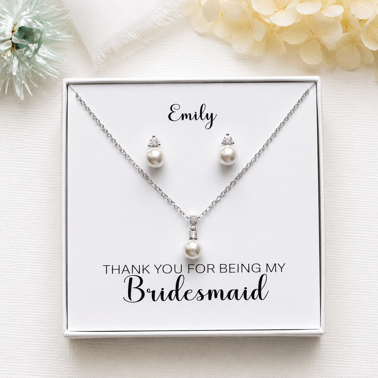 A necklace and earrings set presented in a white box, with a personalized message on the box.