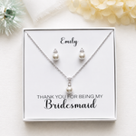 A necklace and earrings set presented in a white box, with a personalized message on the box.