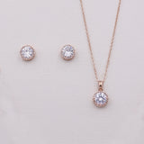 a delicate gold necklace and earrings set with a large, sparkling crystal pendant.