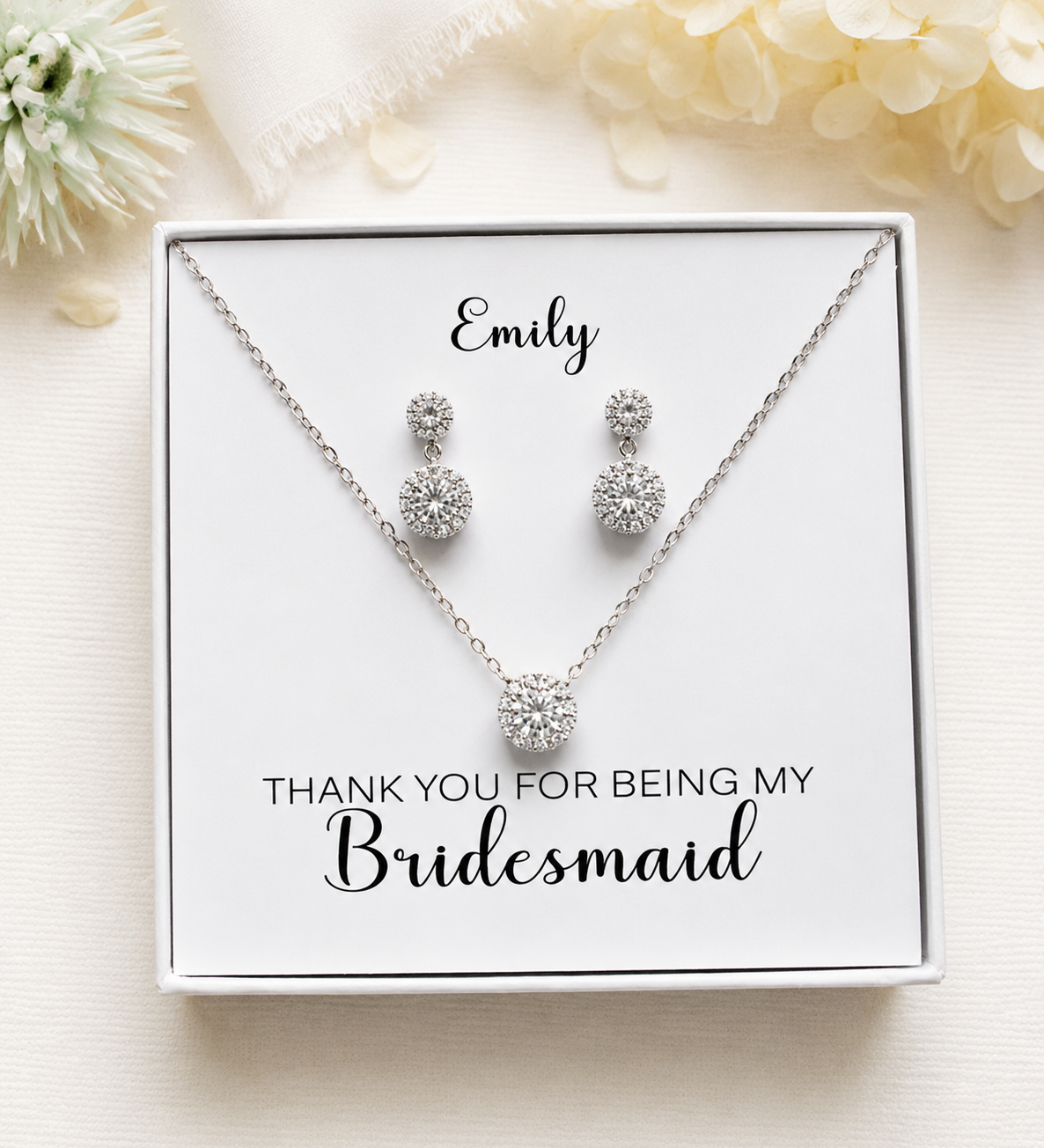 A necklace and earrings set in a white box, with a personalized message on the box.