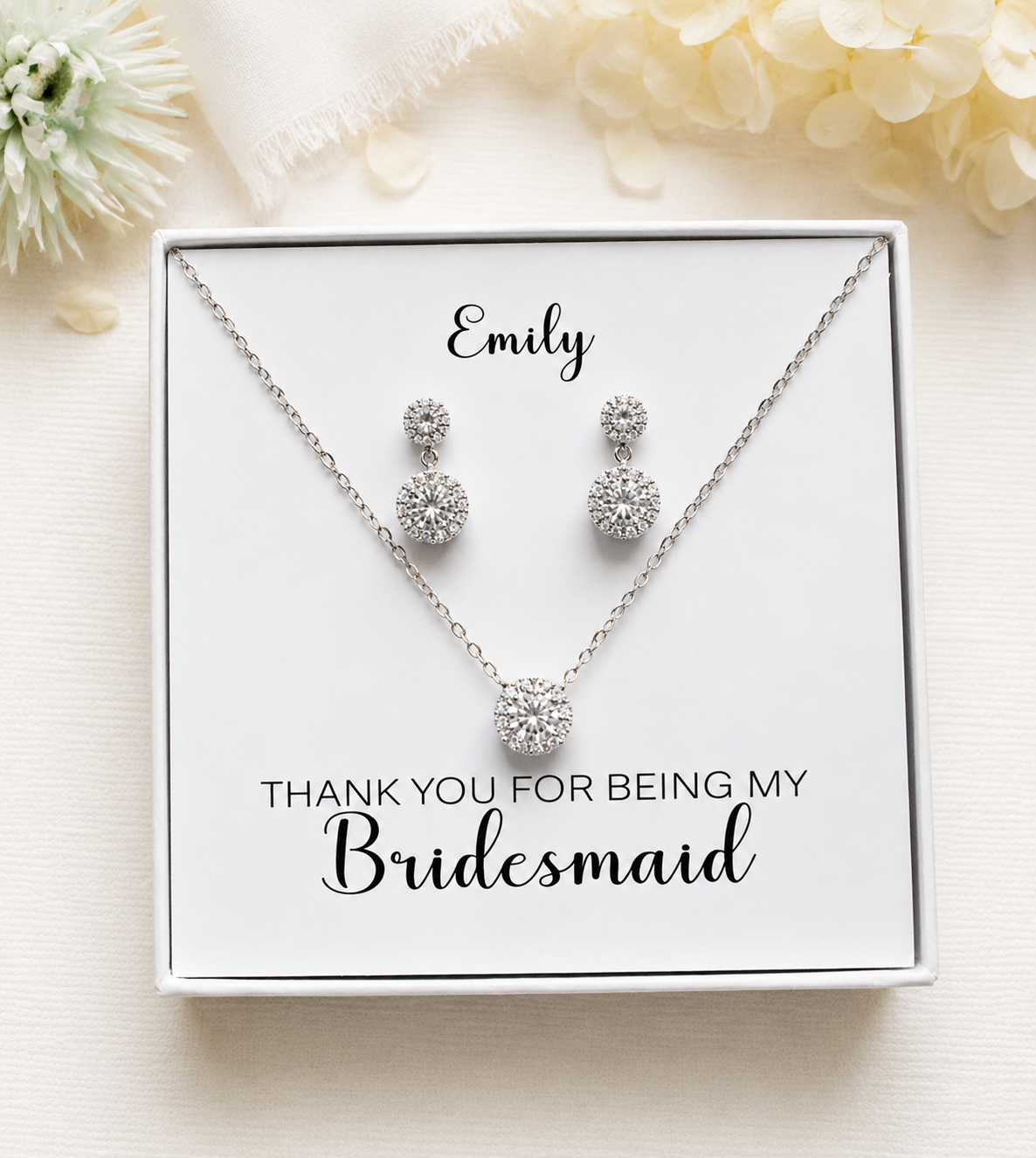 A necklace and earrings set in a white box, with a personalized message on the box.