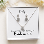A necklace and earrings set in a white box, with a personalized message on the box.