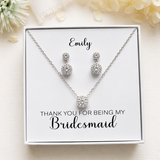 A necklace and earrings set in a white box, with a personalized message on the box.