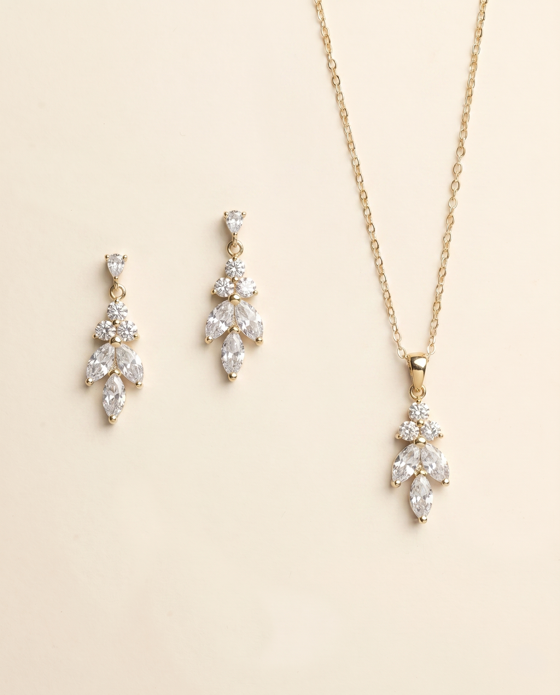 A necklace and earrings set against a light beige background.