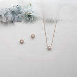 a necklace, earrings, and bracelet on a white surface