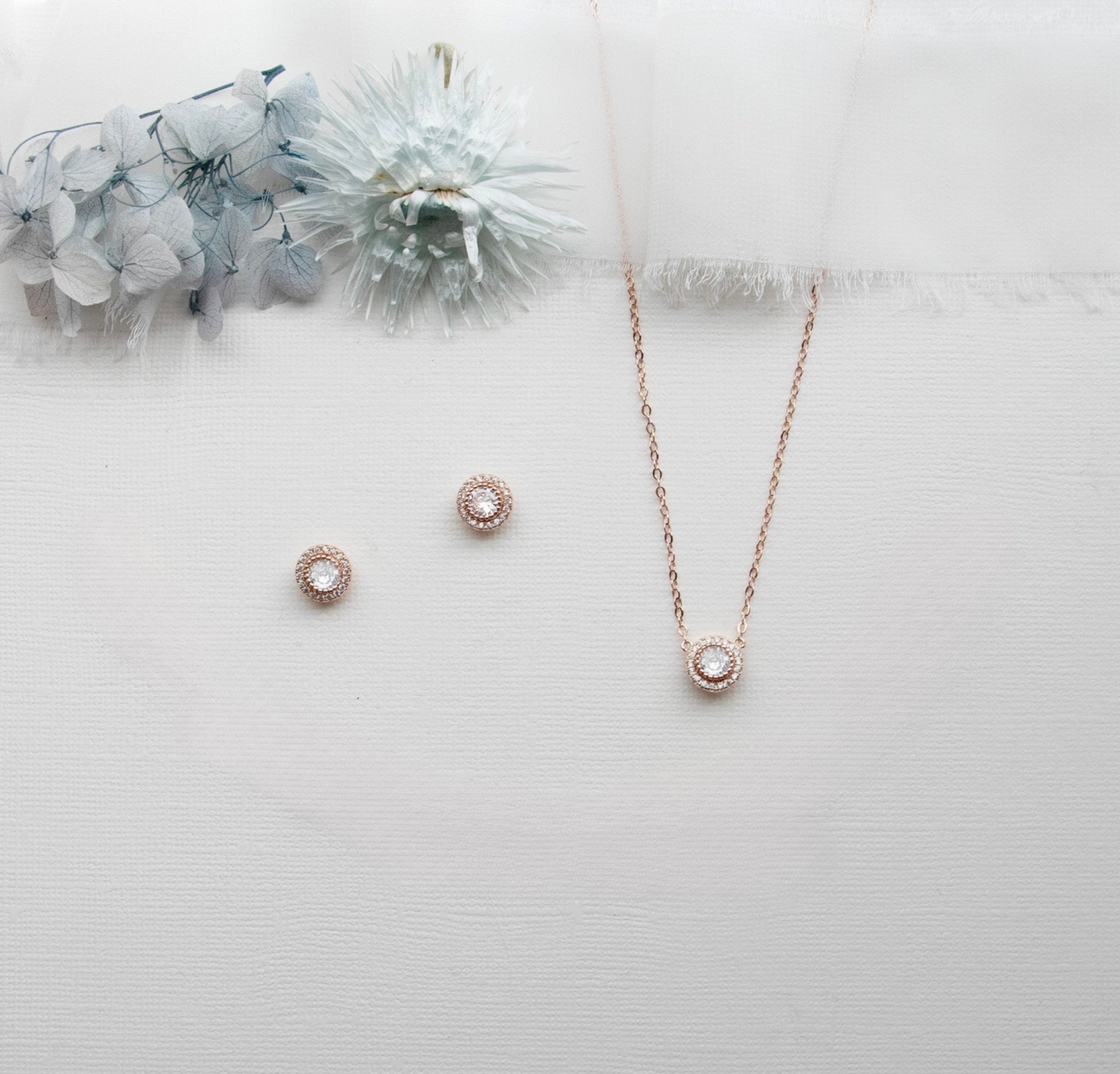 a necklace, earrings, and bracelet on a white surface