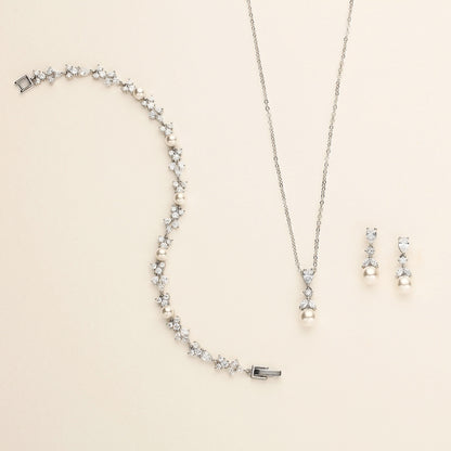 a necklace, earrings, and bracelet on a white surface