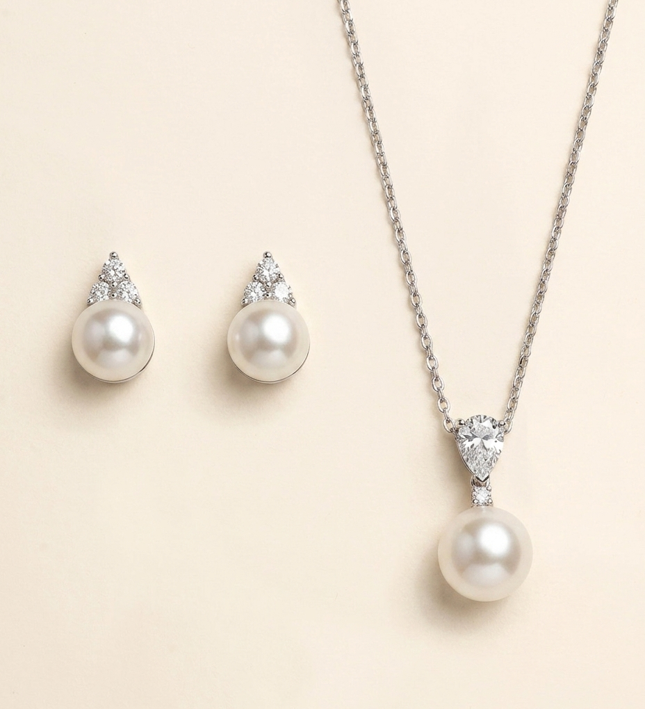 A necklace with a pendant and earrings made of pearls and diamonds.