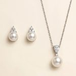A necklace with a pendant and earrings made of pearls and diamonds.