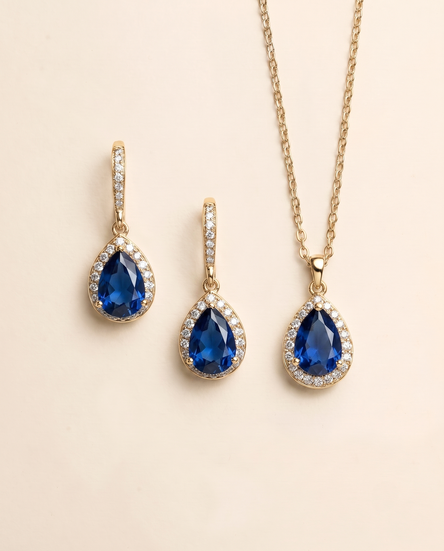 A gold necklace and earrings set with blue gemstones.