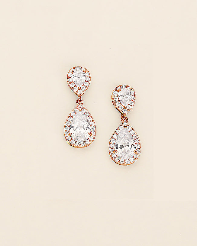 a pair of diamond earrings on a white background