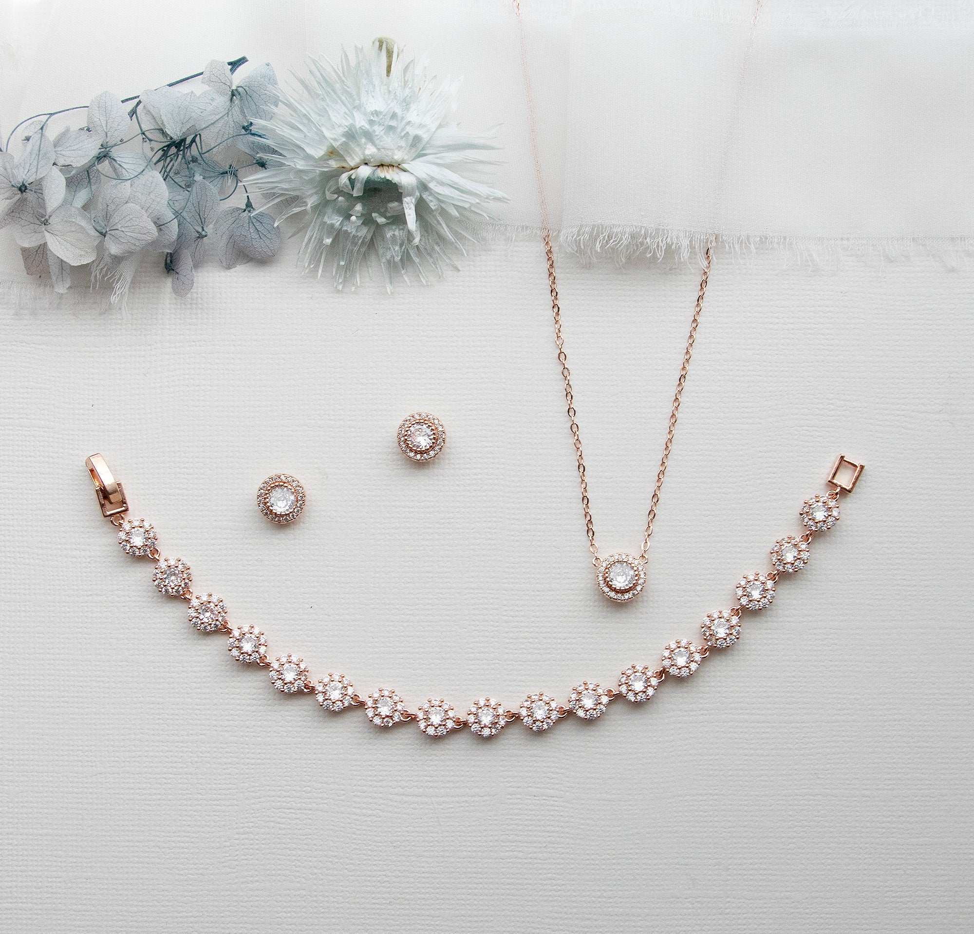 a necklace, earrings, and bracelet on a white surface