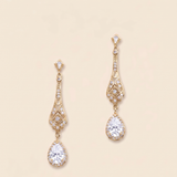 A pair of elegant gold earrings with large, clear gemstones hanging from the bottom.