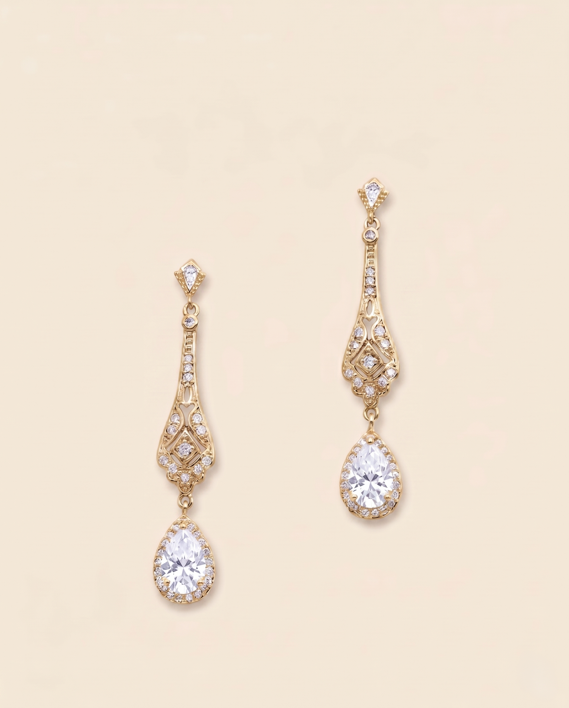 A pair of elegant gold earrings with large, clear gemstones hanging from the bottom.