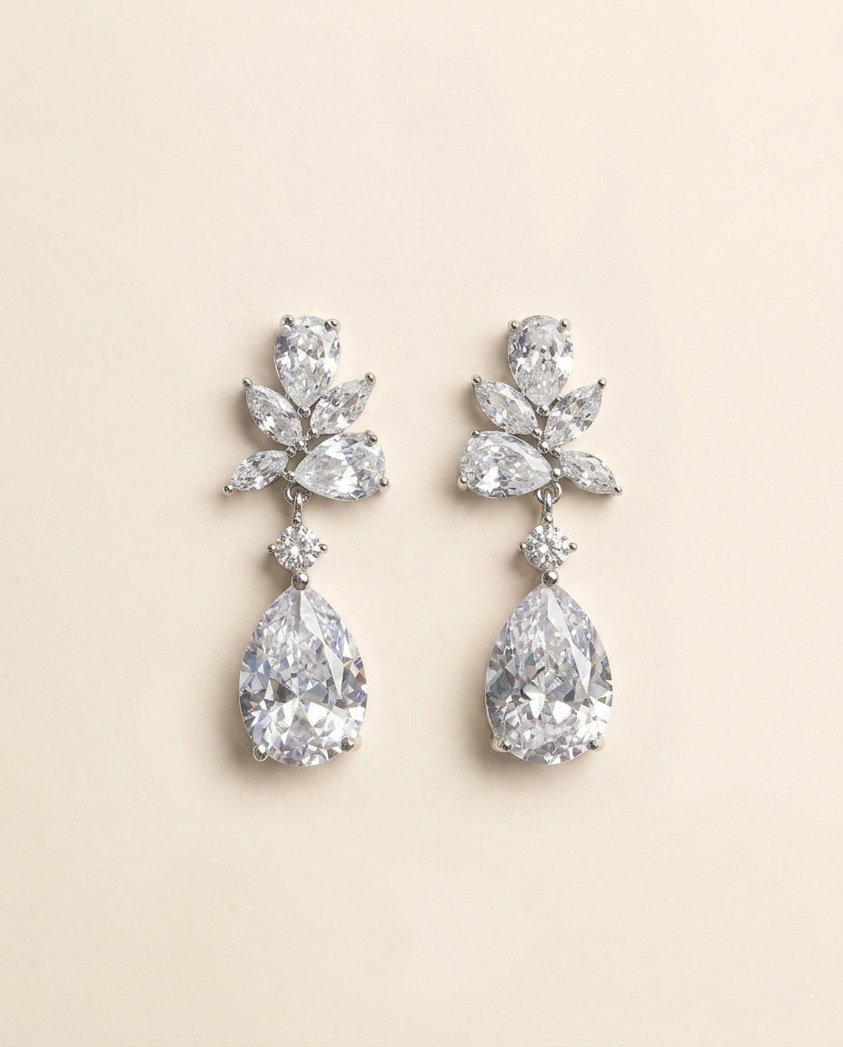 A pair of elegant diamond earrings with large, clear gemstones set in a delicate, floral-inspired design.