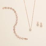 a necklace, earrings, and bracelet on a white surface