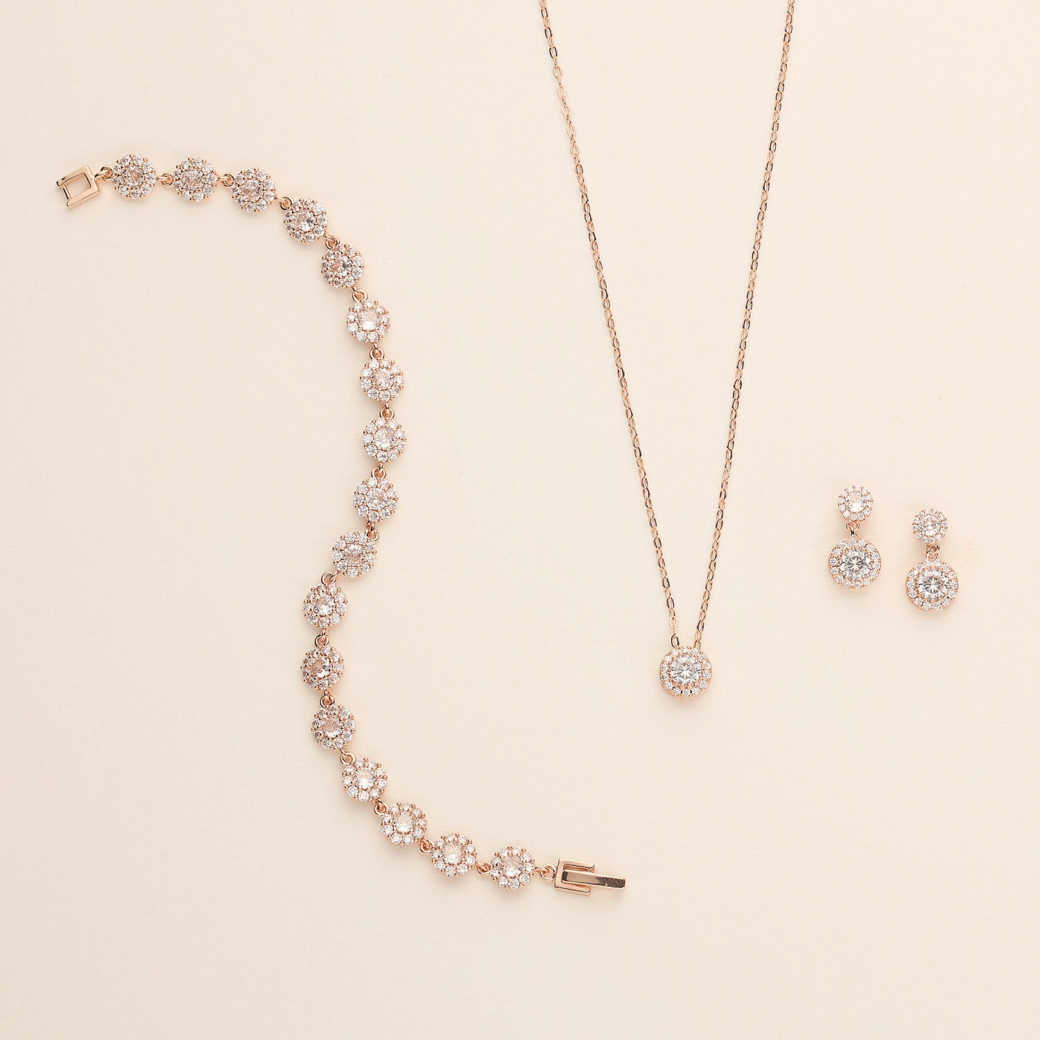 a necklace, earrings, and bracelet on a white surface