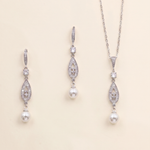 A necklace and earrings set made of silver and white pearls, with dangling crystal pendants.