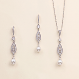 A necklace and earrings set made of silver and white pearls, with dangling crystal pendants.