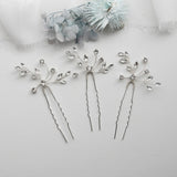 three silver hair pins with flowers on them