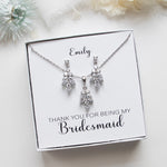 A necklace and earrings set with a personalized message on a white background.
