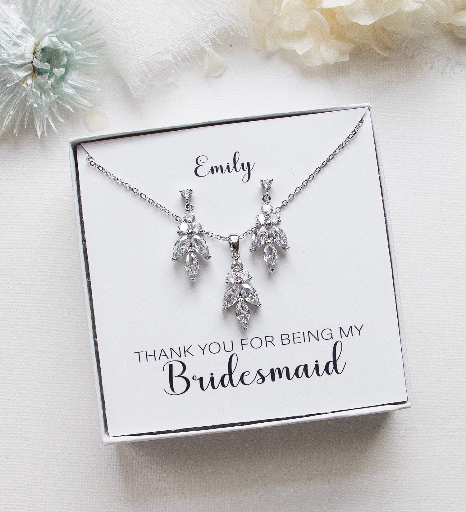 A necklace and earrings set with a personalized message on a white background.