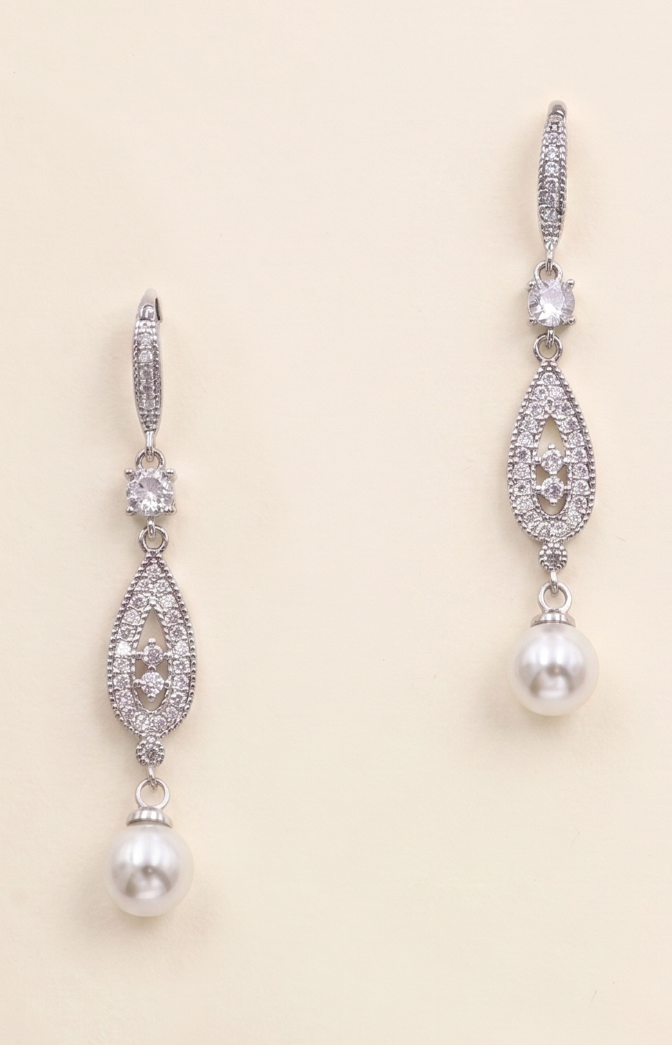 A pair of elegant earrings with pearls and diamonds, featuring a delicate and intricate design.