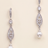 A pair of elegant earrings with pearls and diamonds, featuring a delicate and intricate design.