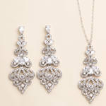 a set of elegant jewelry pieces, including earrings and a necklace, both adorned with intricate designs and sparkling crystal elements.