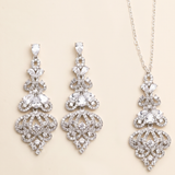 a set of elegant jewelry pieces, including earrings and a necklace, both adorned with intricate designs and sparkling crystal elements.