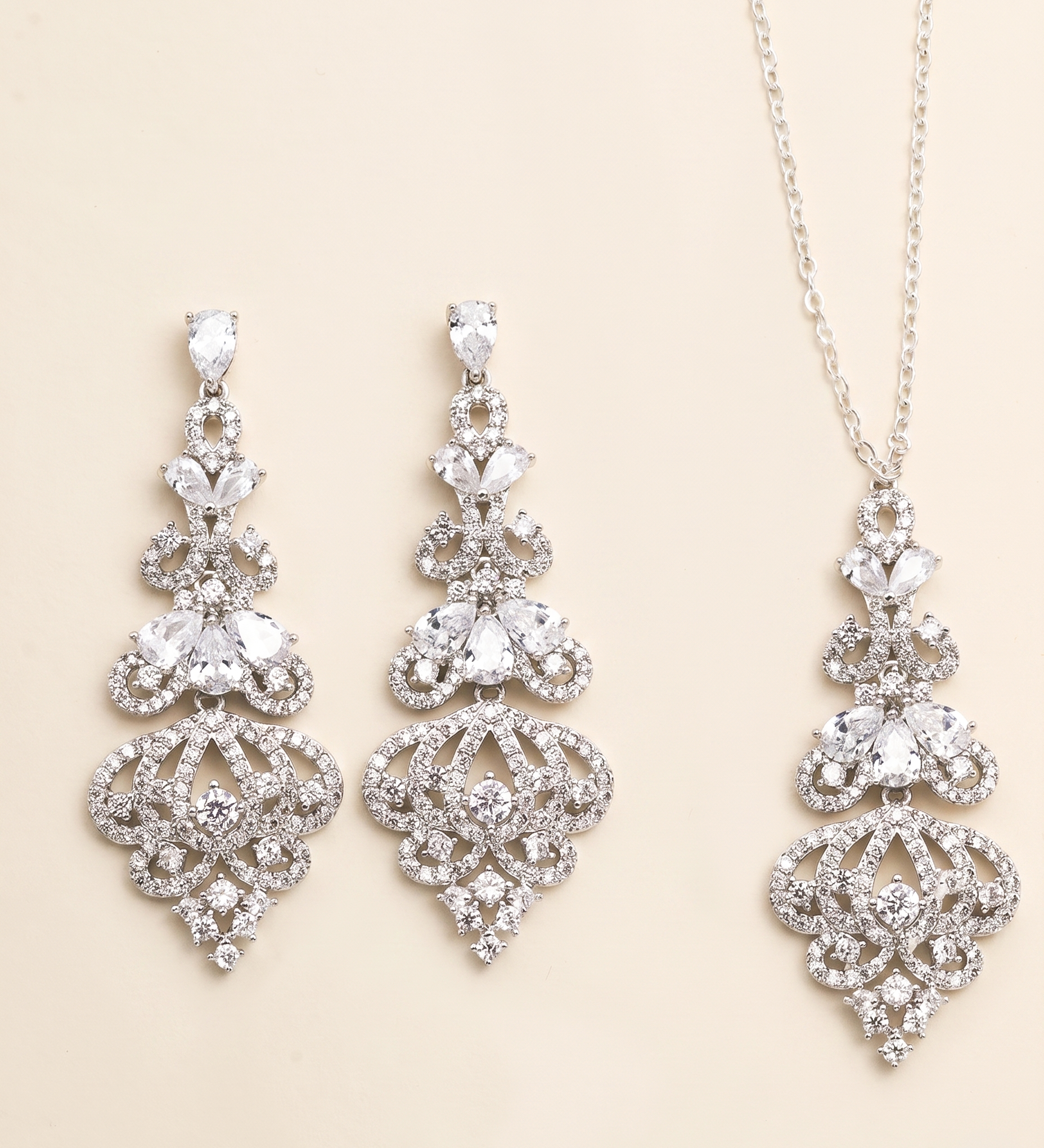 a set of elegant jewelry pieces, including earrings and a necklace, both adorned with intricate designs and sparkling crystal elements.
