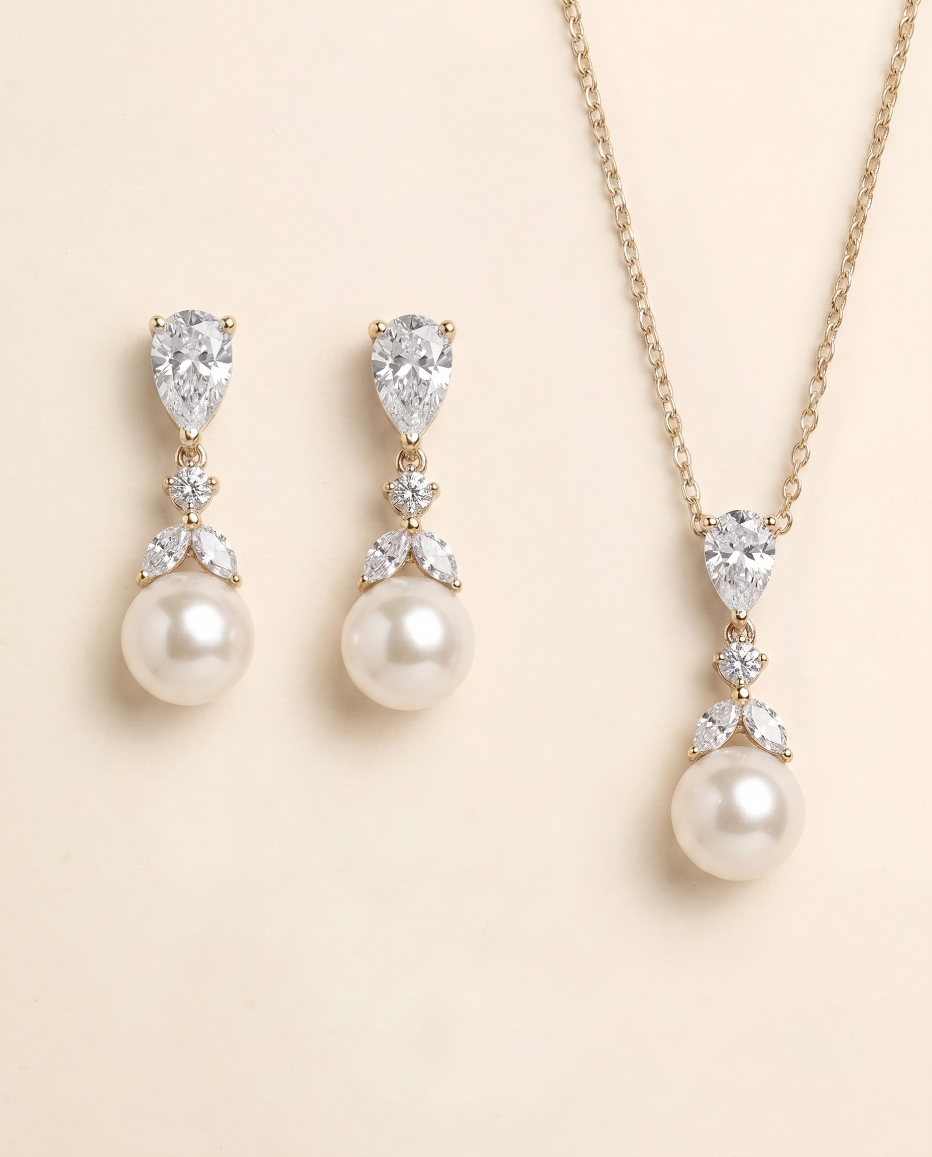 A set of elegant pearl and diamond jewelry, including earrings and a necklace, displayed against a light beige background.