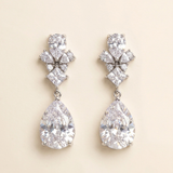 A pair of elegant earrings with large, clear gemstones hanging from the ear lobes.