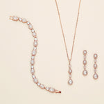 a necklace, bracelet, and earrings on a white surface