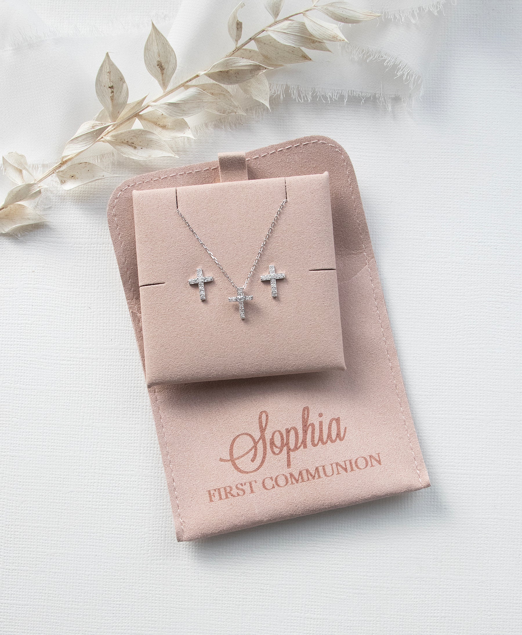 A necklace with two cross pendants and a matching cross pendant set in a tan-colored box, labeled "Sophia First Communion"