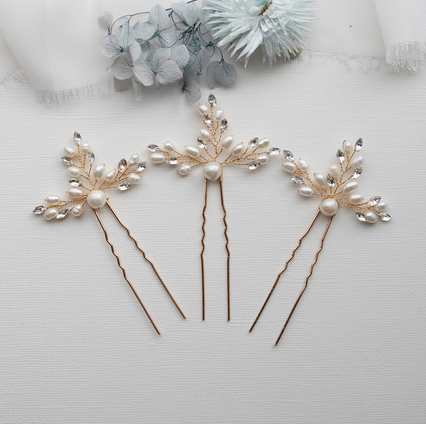 three hair pins with pearls and leaves on them