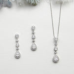 a collection of elegant jewelry pieces, including a necklace, earrings, and a pendant, all featuring a sparkling diamond design.