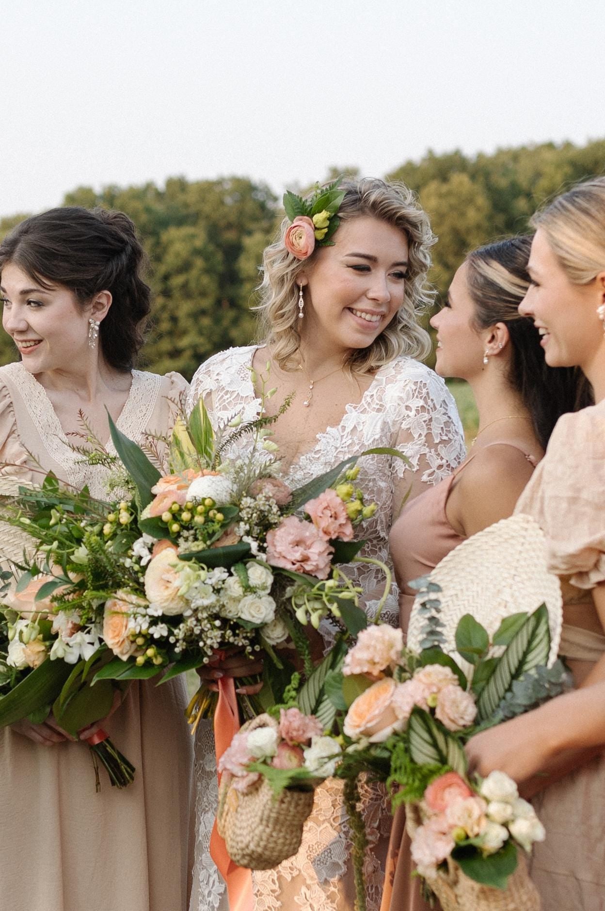 A group of women, presumably bridesmaids, standing together and holding bouquets of flowers.