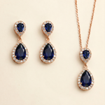 A pair of elegant earrings and a necklace featuring a combination of blue gemstones and sparkling diamonds.