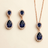 A pair of elegant earrings and a necklace featuring a combination of blue gemstones and sparkling diamonds.