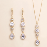 a set of elegant gold jewelry pieces, including earrings and a necklace, featuring a delicate and intricate design with numerous small pear-shaped gemstones.