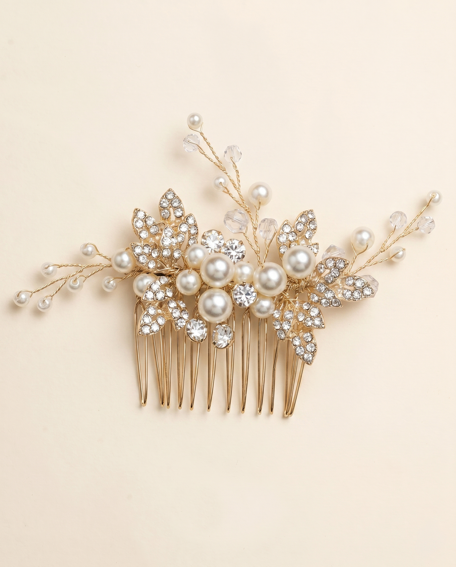 A decorative gold hairbrush adorned with pearls and crystal embellishments.