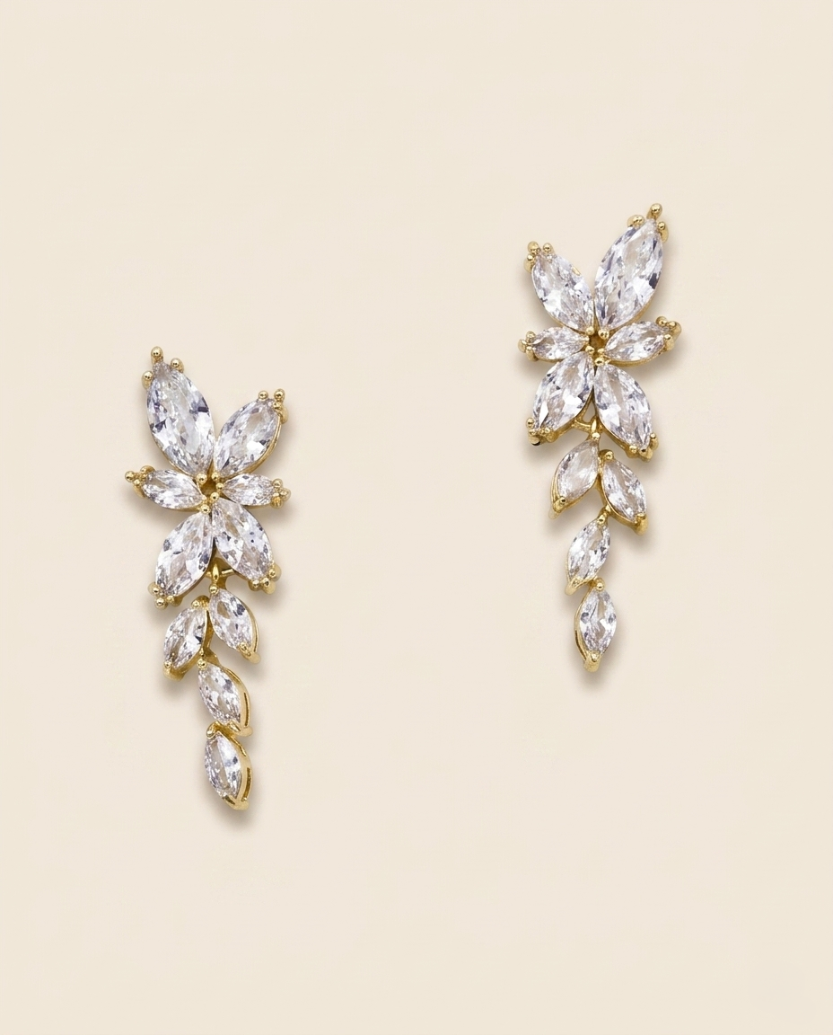 two elegant gold earrings with clear gemstones, showcasing their intricate designs and sparkling appearance.