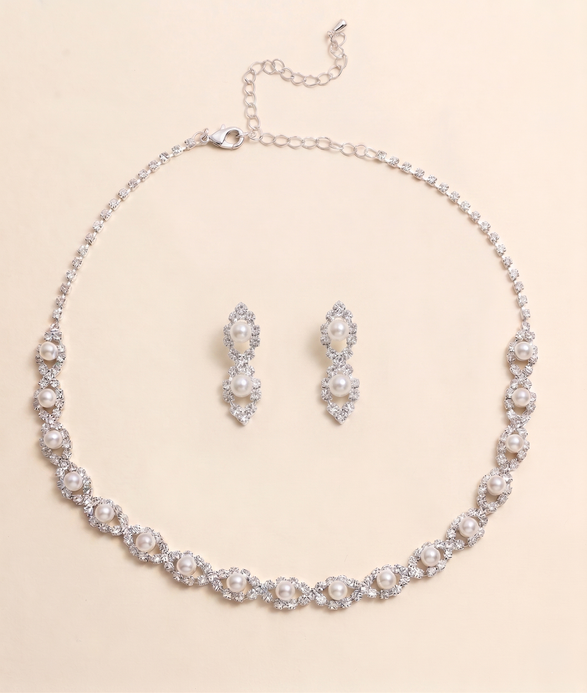 A necklace and earrings set made of silver and white pearls, with a chain and clasp.