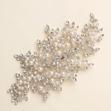 a decorative piece of jewelry with a combination of pearls and crystals, including a large cluster of pearls and smaller crystals arranged in a visually appealing manner.